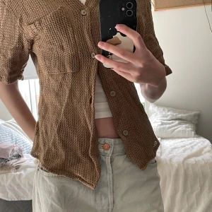 Brun stickad skjorta från Zara - Säljer en beige stickad skjorta från Zara i relaxed fit. Skjortan har korta ärmar, knappar framtill och en bröstficka. Materialet är grovstickat och luftigt. Aldrig använd av mig men köpt secondhand.  Vet inte om det är dam eller herr men sitter ganska tight.