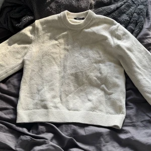 Beige stickad tröja från Gina Tricot - En stilren beige stickad tröja från Gina Tricot med rund halsringning och ribbade muddar vid ärmslut och nederkant, som inte är sticksig. Tröjan har en klassisk passform men är i använt skick. Som man kan se på bilden är tröjan inte lika ”fräsch” i färgen som den var innan och därför säljer jag till billigt pris💕