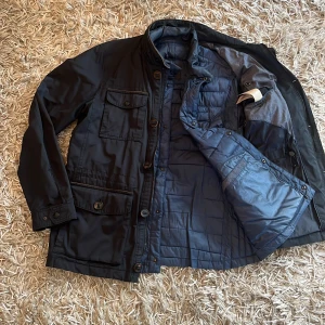Massimo Dutti Fieldjacket: M - Säljer en fieldjacket ifrån Massimo Dutti som är i väldigt fint skick. Jackan är i storlek L men sitter som M. Den har även en väst innuti som du kan koppla bort och använda som väst eller ta ur för att göra jackan svalare❄️. Jackan är alltså perfekt för lite varmare höst dagar men även kyliga höst och vinter dagar. Hör av er till om ni har yttligare funderingar😊 (OBS! Va inte rädda för att skicka bud😁)