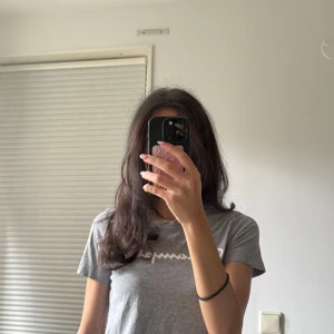 Grå Champion t-shirt XS - Snygg grå t-shirt från Champion i storlek XS. T-shirten har klassisk passform, rund halsringning och vit Champion-logga framtill samt liten logga på ärmen. Perfekt basic med sportig vibe och mjukt bomullsmaterial.