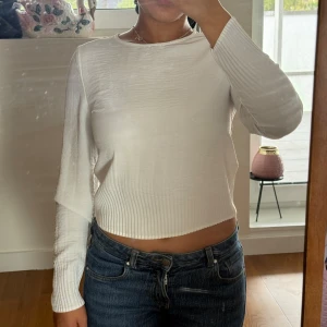 Vit långärmad topp från Vero Moda - Säljer en stilren vit långärmad topp från Vero Moda. Toppen har en lätt ribbad struktur nedtill, är croppad och har rund halsringning. Perfekt att matcha med jeans eller kjol för en clean look.