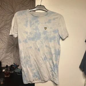 Ljusblå tie-dye t-shirt från Lyle & Scott - Säljer en fräsch ljusblå och vit tie-dye t-shirt från Lyle & Scott den är exklusiv då det är en blandning av vit och blå samt ett väldigt fint skick 