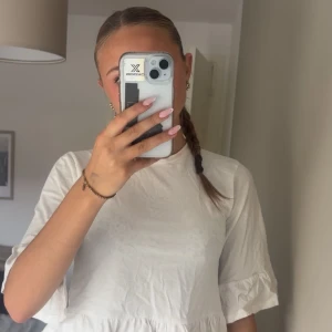 Vit volangblus från Nelly - Supersöt vit blus från Nelly i bomull med volangdetaljer längst ner och på ärmarna. Blusen har rund halsringning och halvlånga ärmar. Perfekt för dig som gillar en feminin och enkel stil. Säljer för den är för liten 💕 skriv för flera bilder 