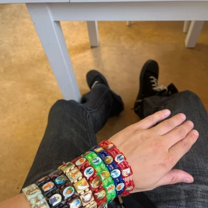 Färgglada religiösa armband - Säljer flera coola armband med religiösa motiv i olika färger som rött, blått, grönt, svart, beige och brunt. Varje armband har små bilder på helgon och ikoner, och är gjorda av plast och trä. Perfekt för dig som gillar unika accessoarer med lite retrovibe och färg.