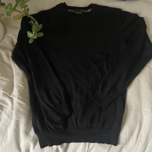 Svart tröja i merinoull från Sand Copenhagen  - Klassisk svart rundhalsad tröja i 100% merinoull från Sand Copenhagen. Tunnstickad modell med ribbade muddar vid ärmslut och nederkant.                               📏 Storlek: M ✨ Skick: Lite använd men i mycket bra skick, inga fläckar eller hål. 🧵 Material: Merinoull – mjuk, skön och värmande.       ✅ Pris kan diskuteras