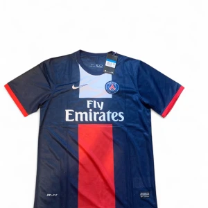 PSG Ibrahimović 10 matchtröja Nike - Paris Saint-Germain fotbollströja med Ibrahimović och nummer 10 på ryggen. Tröjan är marinblå med röd mittremsa, vita detaljer och röda ärmslut. Tillverkad i lätt och ventilerande Dri-FIT-material. Klassisk rund hals och klubbmärke på bröstet.