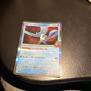 ロケット団のフリーザー (Team Rocket's Articuno) - En japansk Pokémon-samlarkort med Articuno från Team Rocket-serien. Perfekt för dig som älskar Pokémon och vill utöka din samling med en unik och cool holo-kort! Kortet har snygg design och är ett måste för fans av både spel och anime.