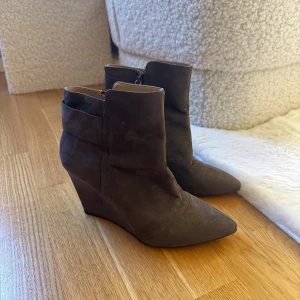 Bruna kilklacksboots från Zara - Snygga bruna boots från Zara med kilklack och spetsig tå. Skorna är i mocka och har dragkedja på insidan. Är i storlek 41, men skulle snarare säga att de passar bäst för strl 40