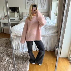 Ljusrosa mohairstickad tröja - Supermysig ljusrosa stickad tröja med oversized passform och långa ärmar. Tröjan har en enkel rund halsringning och är gjord i ett fluffigt material som känns extra skönt mot huden. Perfekt att slänga på sig när det är lite kyligt ute.