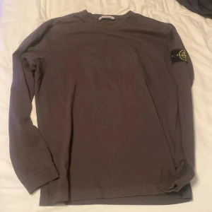Brun långärmad tröja Stone Island - Säljer en mörkgrå långärmad tröja från Stone Island . Tröjan har rund hals och är gjord i mjuk bomull, perfekt för chill dagar. Enkel och stilren design som funkar till det mesta.