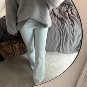 Långa hög/mid waist jeans  - Ljusblå jeans med flera knappar och fickor där fram 