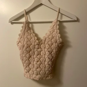 Beige linnetopp med spets - Beige croppad linnetopp med smala axelband och v-ringning, med blommönster och spetsdetaljer. Väldigt gott skick och bara använd ett fåtal gånger🩷
