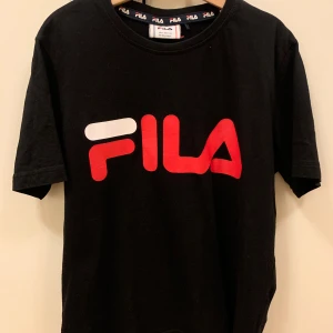 Snygg svart FILA t- shirt, stl 146-152 - Säljer en snygg svart t-shirt av märket FILA med tryck fram. Sparsamt använd så den är i fint skick. 