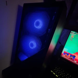 Gaming PC med RGB-belysning - Snygg gamingdator med blå RGB-fläktar och stilren design. Perfekt för spel, som visas på bilderna. men är i gott skick. Levereras med bakgrundsbelyst tangentbord och skärm. Fungerar utmärkt för gaming och vardagsbruk. Två hörlurar medföljer och wireless mus! 