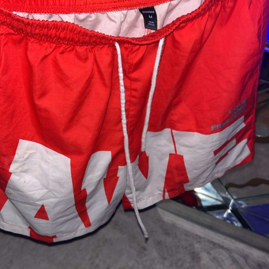 Röda shorts med vit text från ROMWE