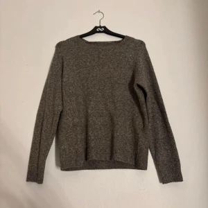 Brun stickad tröja med rund hals - Mysig brun stickad tröja med rund hals och långa ärmar. Tröjan har ribbade muddar vid ärmslut och nederkant, perfekt för lager på lager under kyliga dagar. Enkel och stilren design som passar till det mesta.