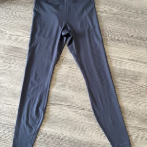 Mörkblå leggings från H&M Move - Snygga mörkblå leggings från H&M Move, perfekta för träning eller chill. De har en tight passform och är gjorda i mjukt syntetmaterial som sitter skönt mot huden. Hög midja för extra komfort och stilren look. Underdelen är S och överdelen är M