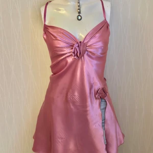 Rosa satin klänning med rosettdetaljer - Defects appear in the pictures 