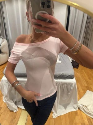 Ljusrosa offshoulder topp - Snygg ljusrosa topp med offshoulder-design och korta ärmar. Figurnära passform som ger en trendig look. Perfekt att styla med jeans eller kjol för en cool vibe.