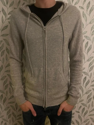 John Henric Kashmir  - Säljer en ljusgrå Kashmir kofta  ifrån märket John Henric. Koftan har inga som helst slags skavanker. Och är i ett utomordentligt skick. Ny pris 2999 kr