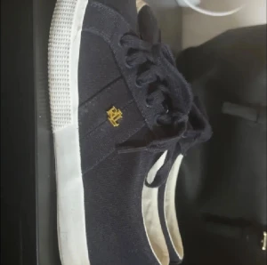 Mörkblå sneakers från Ralph Lauren - Snygga enkla sneakers ifrån Ralph Lauren i en snygg mörkblå färg med guld detalj. Skorna är i bra skick och används 3-4gånger så nästintill som nya💕Skorna är som sagt i strl 38. Skorna säljes då jag ej har användning för de. 