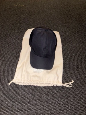 Svart keps från Loro Piana - Tjena! Säljer en stilren keps från Loro Piana. Utsidan är svart med diskret broderad logga framtill. Underskärmen är vit. Skick 9/10. Pris: 2700. Storlek: m. Bara att fråga om det är något!