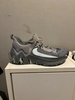 Nike Giannis Immortality 2 – Cool Grey  - Nike Giannis Immortality 2 – Cool Grey (Basketbollskor)  Säljer ett par Nike Giannis Immortality 2 i färgen Cool Grey. Skorna är endast använda en gång och är i mycket fint skick, i princip som nya. Inga skador, minimal till ingen slitage på sula eller ovandel (se bilder).  ✔ Lätta och responsiva basketbollskor ✔ Bra grepp och stabilitet för snabba rörelser ✔ Designade för spelare som gillar fart och kontroll ✔ Passar både match och träning  Låda: ingen Användning: 1 gång 