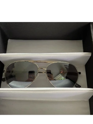 Silvriga aviator solglasögon - Snygga aviator solglasögon med silvrig metallbåge och mörka tonade glas. Klassisk pilotmodell som ger en cool och tidlös look. Passar perfekt till alla stilar och är ett måste i accessoargarderoben.