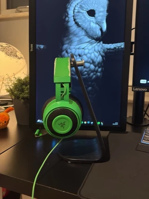 Gröna Razer Kraken gaming headset - Säljer ett par gröna Razer Kraken over-ear gaming headset med kabel. De har stora, mjuka öronkuddar och justerbar huvudbygel för extra komfort. Perfekt för gaming med tydligt ljud. Har använt dessa hörlurar i ca 1,5 år och dom är definitivt dom bästa hörlurarna jag ägt när det kommer till ljud, det har blivit lite slitage på hörlurarna pågrund av användning och därför erbjuder jag det väldigt låga priset!! 