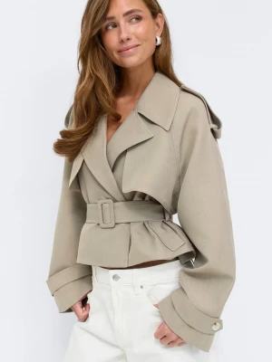 Kort beige trenchcoat med bälte - Trendig kort trenchcoat i beige med axelklaffar och bälte i midjan. Jackan har vida ärmar med dekorativa knappar vid ärmsluten och en snygg oversized passform. Helt slutsåld på hemsidan, endast provad, storlek XS