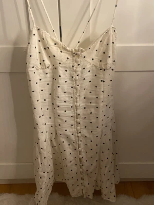 Superfin prickig sommarklänning Zara☀️🥹 - Söt vit klänning med svarta prickar och tunna axelband. Klänningen har knappar framtill och är tillverkad i ett lätt material, perfekt inför sommaren. OBS en knapp saknas på klänningen annars gott skick! 