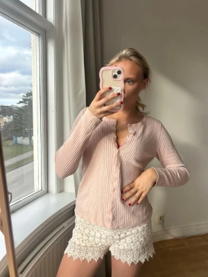 Ljusrosa ribbad kofta med knappar💖💖 - Söt ljusrosa kofta med ribbad struktur och rund halsringning. Koftan har långa ärmar och stängs med matchande knappar framtill. Perfekt att styla med både jeans och kjol för en trendig look.