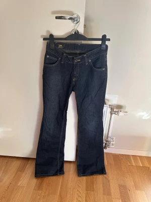 Mörkblå bootcut jeans från Lee - Snygga mörkblå jeans från Lee med klassisk bootcut passform och kontrastsömmar. Storleken är 27-31 men skulle säga att det passar storlek S.