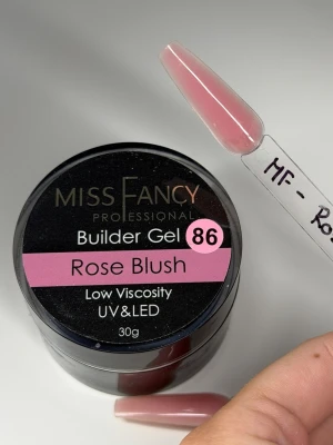 Builder Gel Rose Blush från Miss Fancy - Builder Gel Rose Blush från Miss Fancy är en bygggel för naglar med låg viskositet, perfekt för UV och LED-härdning. Färgen är en mjuk, rosatonad blush som ger ett naturligt och fräscht intryck. Kommer i en rund burk på 30g och har en slät, geléaktig konsistens.
