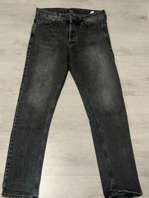 Svarta raka jeans från Zara - Säljer ett par svarta raka jeans från Zara Denim Wear. Jeansen har en klassisk femficksmodell, normal midja och är tillverkade i slitstark denim. Snygg tvättad look med subtila slitningar för en trendig vibe.