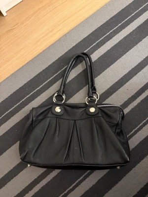 Väska - Jättesnygg väska, den var sönder när jag köpte den men den har några defekter (se bild) köpt i rizzo affären, det syns inte att den är sönder när man har den på sig