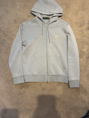 Ralph Lauren Zip - Ralph Lauren zip🌟| Bra skick och inga synliga defekter | Storlek S men sitter mer som en XS | Ljusblå och skön färg inför våren | Killen på bilden är 175 | Kom privat för fler bilder eventuellt frågor angående tröjan, mvh Max😄