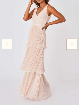 Lång volang klänning - Lång volang klänning i en ljusrosa färg! Aldrig använd med lappar kvar, storlek 34 men skulle säga att den även passar 36! Nypris ca 1100kr