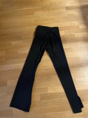 Svarta utsvängda leggings S - Svarta leggings med utsvängda ben i mjukt och stretchigt material. Tillverkade av polyester och elastan för en bekväm passform. Perfekta för en avslappnad och trendig stil.