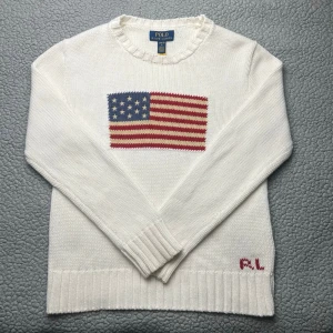 Vit stickad USA Ralph Lauren tröja - Vit stickad tröja från Polo Ralph Lauren med amerikansk flagga✅ mycket bra skick👕 skickar snabbt efter att du har beställt📦storlek L 14-16, ca XS i herrstorlek.  frågor? Skicka ett meddelande! 