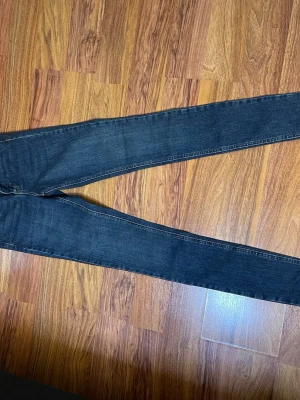 Mörkblå high waist jeans från Gina Tricot - Snygga mörkblå jeans från Gina Tricot i modellen Hannah med high waist och smal passform. Jeansen har premium stretch för extra komfort och klassiska fem fickor. Perfekta för dig som gillar en tight och stilren look.