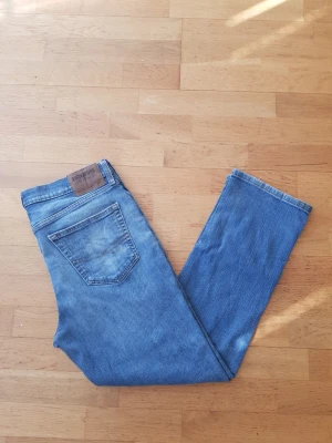 Levi's S67 - Säljer ett par klassiska blå Levi's Signature jeans med rak passform. Jeansen har en snygg tvättad look, fem fickor och läderpatch med logga bak i midjan. Perfekta för en avslappnad stil och funkar året runt.