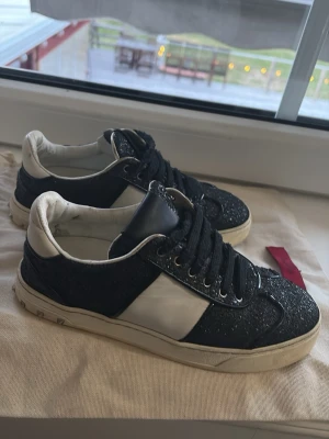 Svarta glittriga sneakers Valentino - Snygga svarta sneakers från Valentino. OBS dem har en defekt med en enda tappad nit annars ganska bra skick, har tyvärr inte boxen kvar endast påsen men dem är äkta. Strlk 35,5 men denhär modellen är väldigt stor i storlek, jag kan ha dessa och jag har normalisätt strlk 36/37