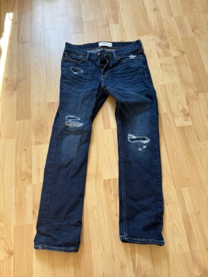 Nudie jeans kids - Mörkblå jeans från Nudie abercrombie med raka ben och slitna detaljer på framsidan. Klassisk femficksmodell och snygga slitningar för en cool look. Perfekta för dig som gillar en avslappnad och trendig stil. Storlek 11/12 