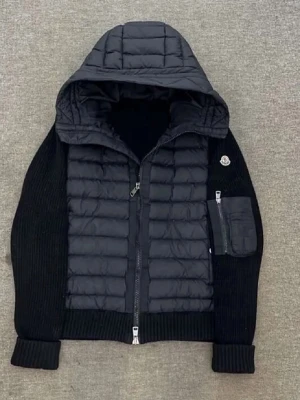 Svart cardigan med huva från Moncler - Snygg blå cardigan från Moncler med stickade ärmar och vadderad front. Jackan har en stor quiltad huva, dragkedja framtill och en praktisk ficka med dragkedja på ena ärmen. Perfekt för kalla vinterdagar och riktigt trendig look.