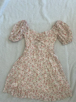 Blommig coquette mini klänning Forever New - Supersöt blommig miniklänning från Forever New med puffärmar, v-ringning och knyt framtill. Pris kan diskuteras! Vill gärna bli av med den snabbt