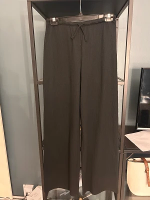 Svarta vida mjukisbyxor H&M - Säljer ett par svarta mjukisbyxor från H&M i storlek 164. Byxorna har en lös och vid passform med dragsko i midjan och är gjorda i ett mjukt, ribbat material. Perfekta för chill dagar eller när du vill ha det extra bekvämt.