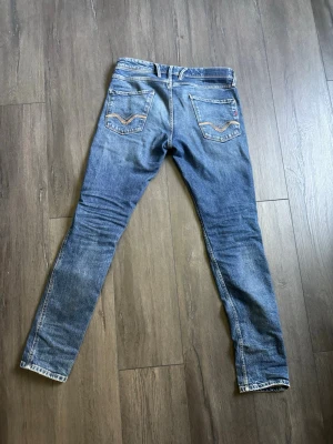 replay anbass  - Säljer ett par blå jeans från replay Jeans med klassisk femficksdesign och snygga slitningar framtill. Jeansen är i storlek 30 32. Tvättade 1 gång nästan aldrig använda så väldigt bra skick.