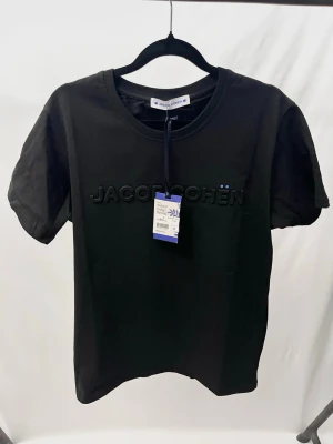 Jacob Cohën T shirt svart - Väldigt stilren och unik Tshirt från det exklusiva märket Jacob Cohën! Helt ny med tags. Storlek S, sitter normalt. Kontakta mig för fler frågor och funderingar!