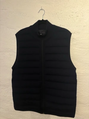 Falconeri- väst  - Falconeri vändbar väst i cashmere- och dunkombination. Ena sidan stickad cashmere och andra sidan lätt dunväst i mörkblå färg. Väldigt bra skick och sparsamt använd. 